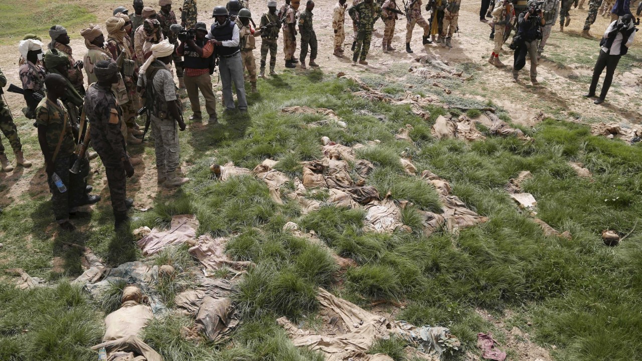 Soldados do Chade e jornalistas observam local onde dezenas de corpos foram encontrados perto da cidade de Damasak, na Nigéria, retomada das mãos dos terroristas do Boko Haram