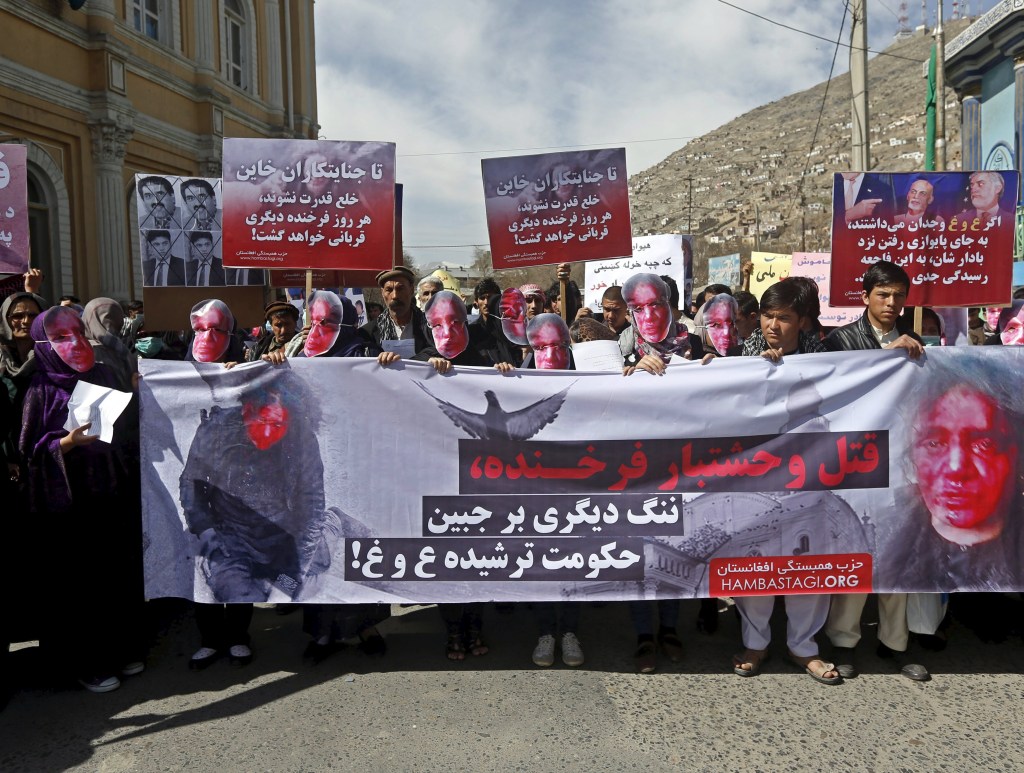 Membros do Partido Solidariedade usam máscaras durante protesto condenando a morte de uma mulher de 27 anos de idade linchada no centro de Cabul. “A morte brutal de Farkhunda é uma vergonha para o governo de unidade nacional”, diz o cartaz, politizando a questão