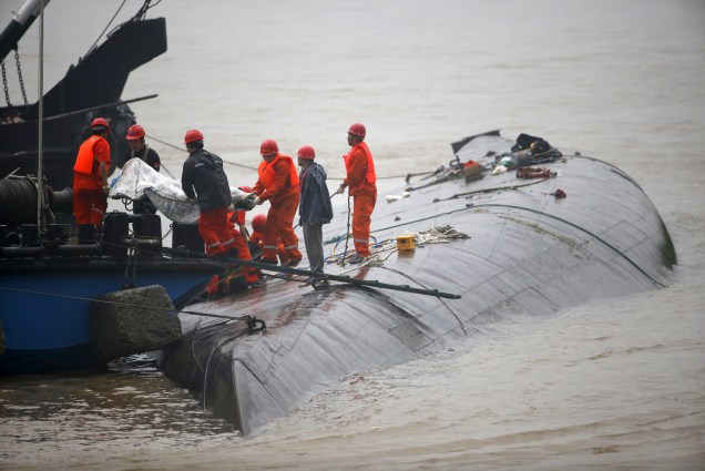 Equipes de resgate retiram um corpo perto de navio naufragado no rio Yang Tsé, na China