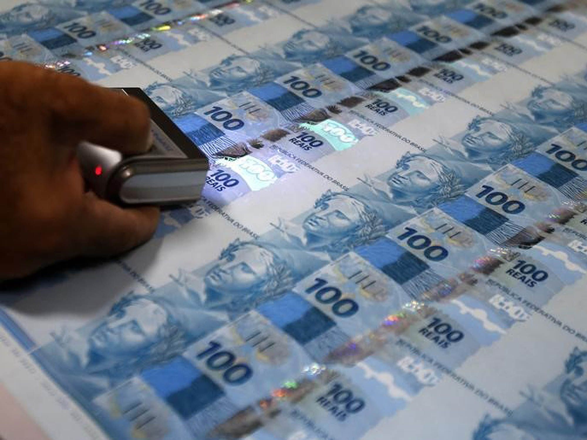Funcionário inspeciona notas de 100 reais recém impressas na Casa da Moeda, no Rio de Janeiro
