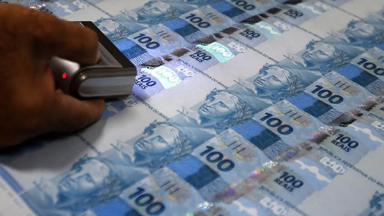 Funcionário inspeciona notas de 100 reais recém impressas na Casa da Moeda, no Rio de Janeiro