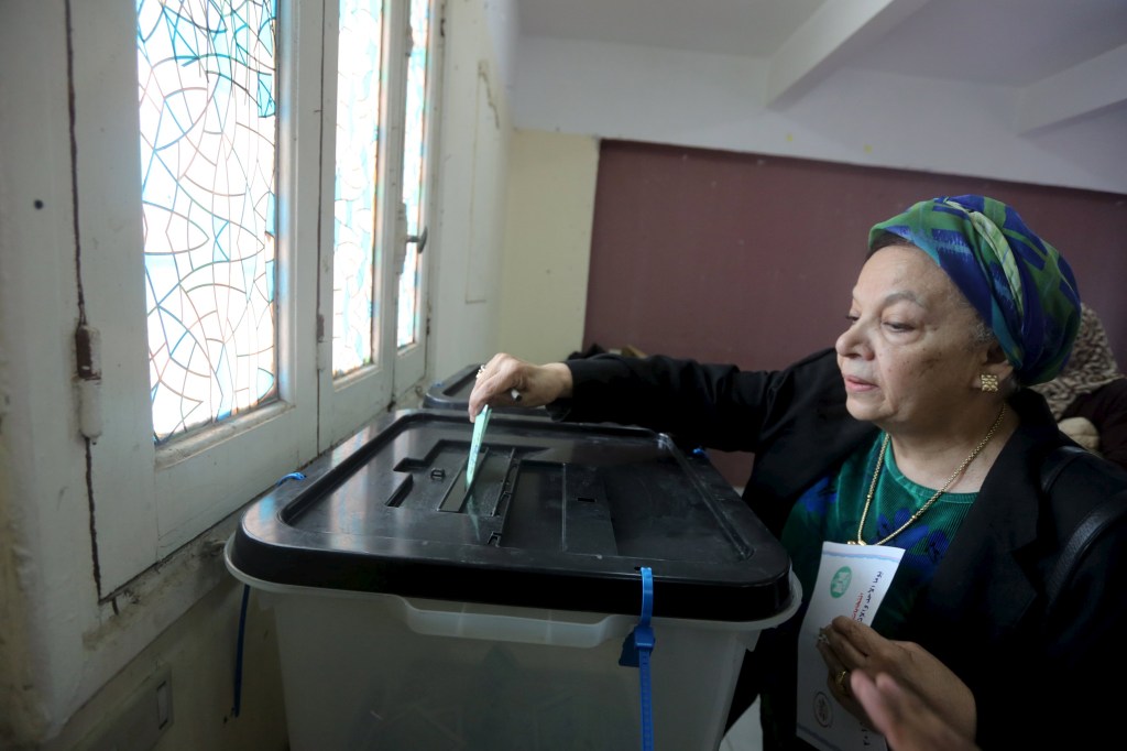 Egípcia deposita voto em Gizé, perto do Cairo, nas eleições parlamentares deste domingo