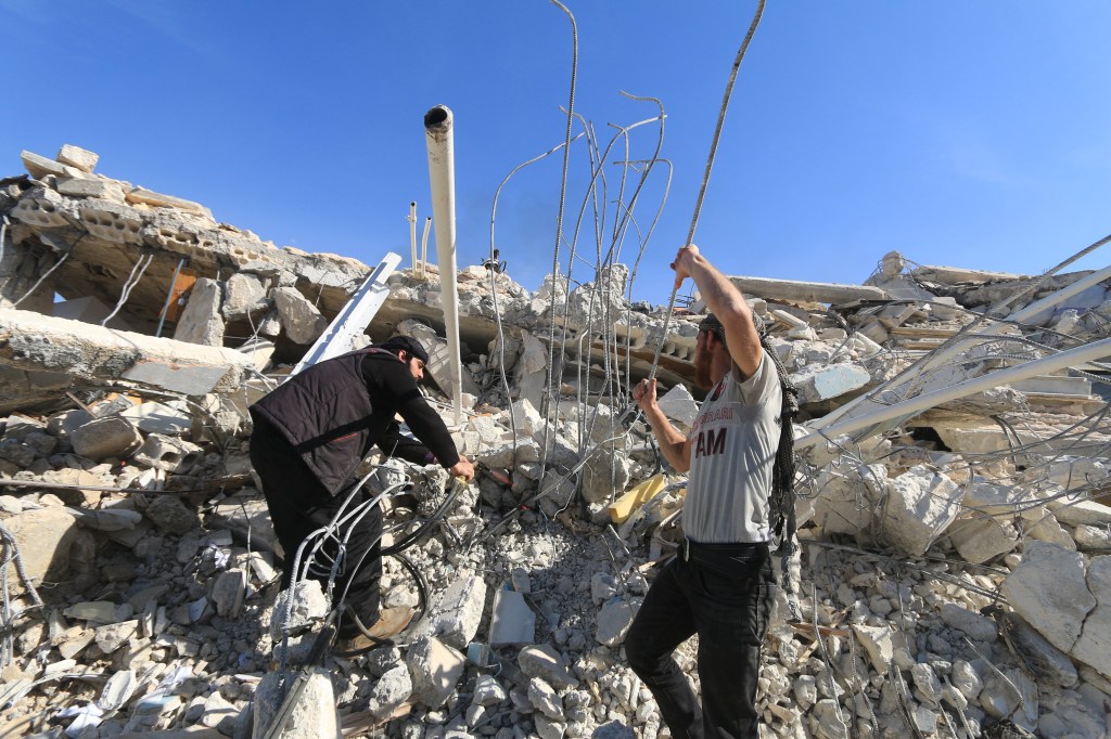 Homens procuram por sobreviventes em escombros de hospital atingido por bombardeio em Marat al-Numan, noroeste da Síria