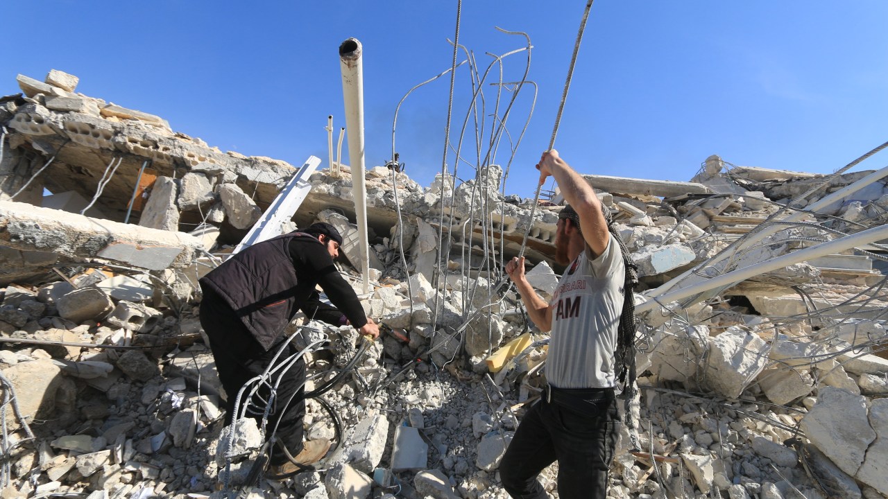 Homens procuram por sobreviventes em escombros de hospital atingido por bombardeio em Marat al-Numan, noroeste da Síria