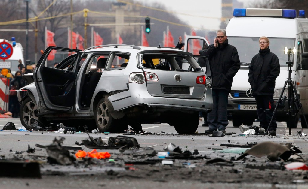 Agentes da polícia alemã avaliam o carro que explodiu em Berlim matando o motorista