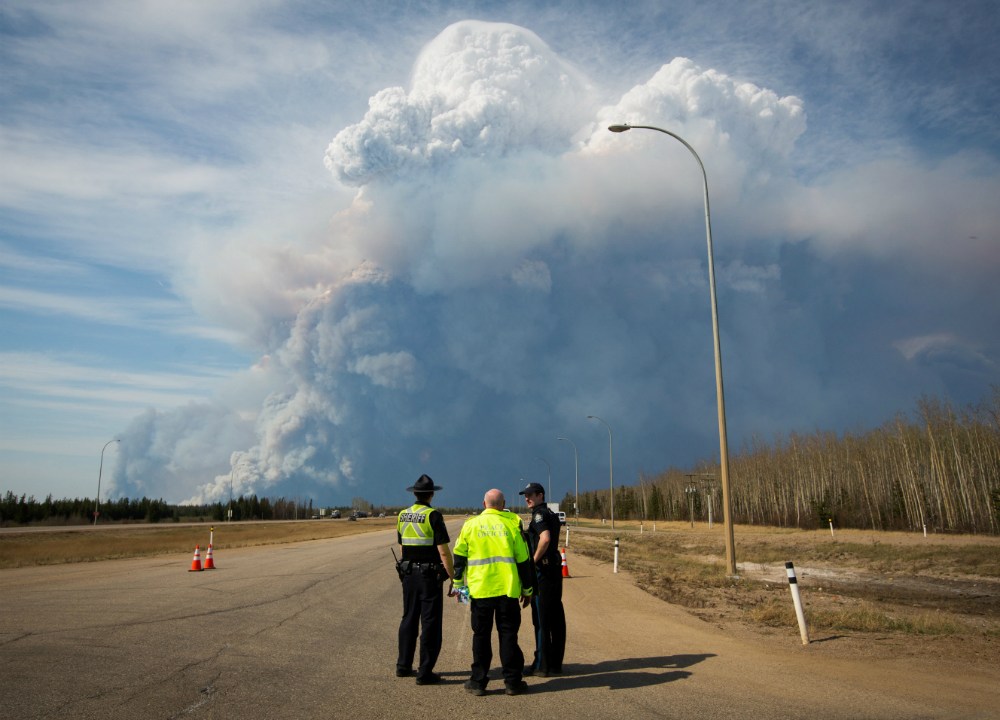 Policiais observam fumaça em Fort McMurray, cidade canadense que precisou ser evacuada após incêndio florestal