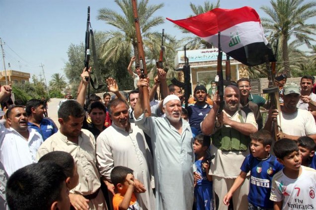 Voluntários iraquianos que se juntaram às forças do Exército comemoram nas ruas de Baquba