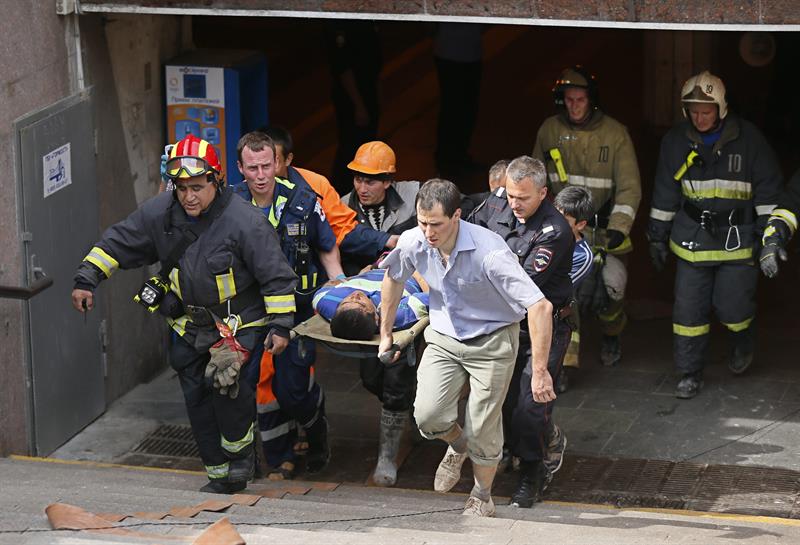 Bombeiros e médicos resgatam um ferido após acidente no metrô de Moscou