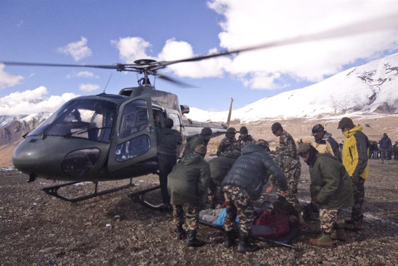 Equipe de resgate socorre um montanhista em área afetada por nevascas, no Nepal