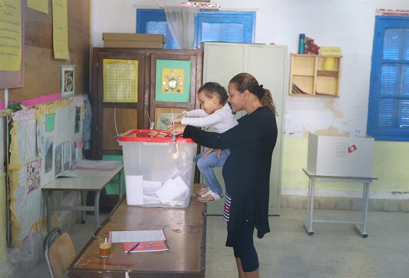 Eleitora vota com sua filha, em Tunis, capital da Tunísia
