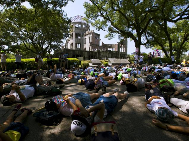Pessoas deitam no chão fingindo de mortos em frente ao Domo da Bomba Atômica, em ato em lembrança às vítimas da bomba que atingiu Hiroshima em 1945, matando cerca de 140 mil pessoas