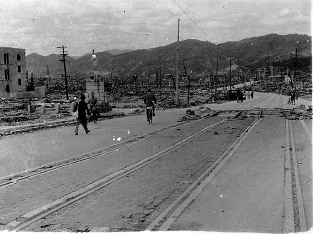 Moradores caminham em frente a prédios destruidos próximo à ponte Aioi, em Hiroshima, após o ataque nuclear à cidade no dia 6 de Agosto de 1945