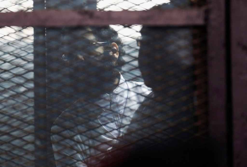 O ativista Alaa Abdel Fattah atrás das grades, antes de seu veredito ser anunciado