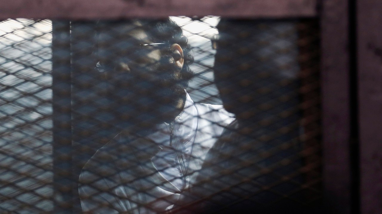 O ativista Alaa Abdel Fattah atrás das grades, antes de seu veredito ser anunciado