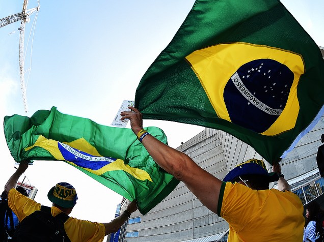 Brasileiros carregam a bandeira do país enquanto seguem em direção ao Rogers Centre em Toronto para a cerimônia de abertura dos Jogos Pan-Americanos 2015