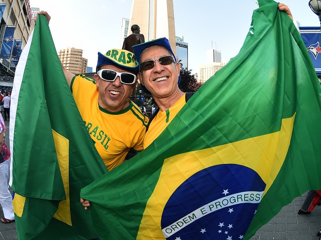Brasileiros carregam a bandeira do país enquanto seguem em direção ao Rogers Centre em Toronto para a cerimônia de abertura dos Jogos Pan-Americanos 2015