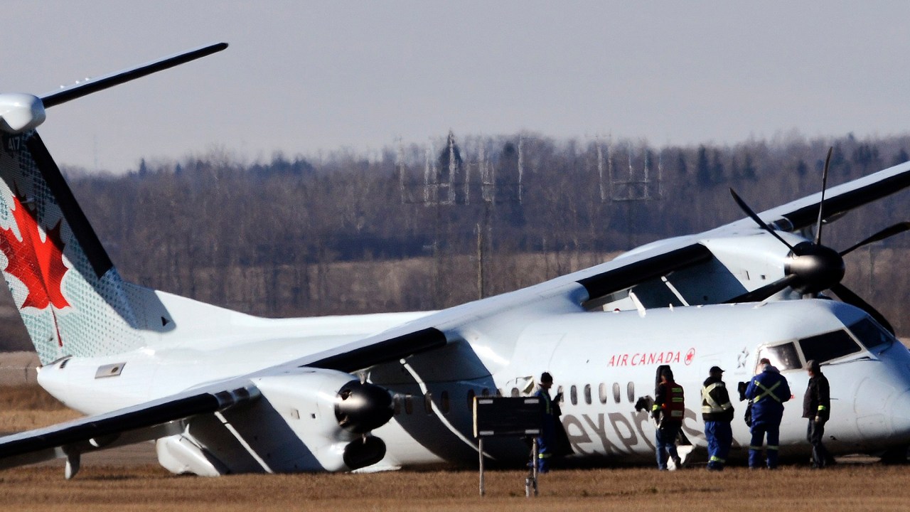 Equipes trabalham em torno da aeronave da compania Air Canada, na pista do Aeroporto Internacional de Edmonton, após uma emergência