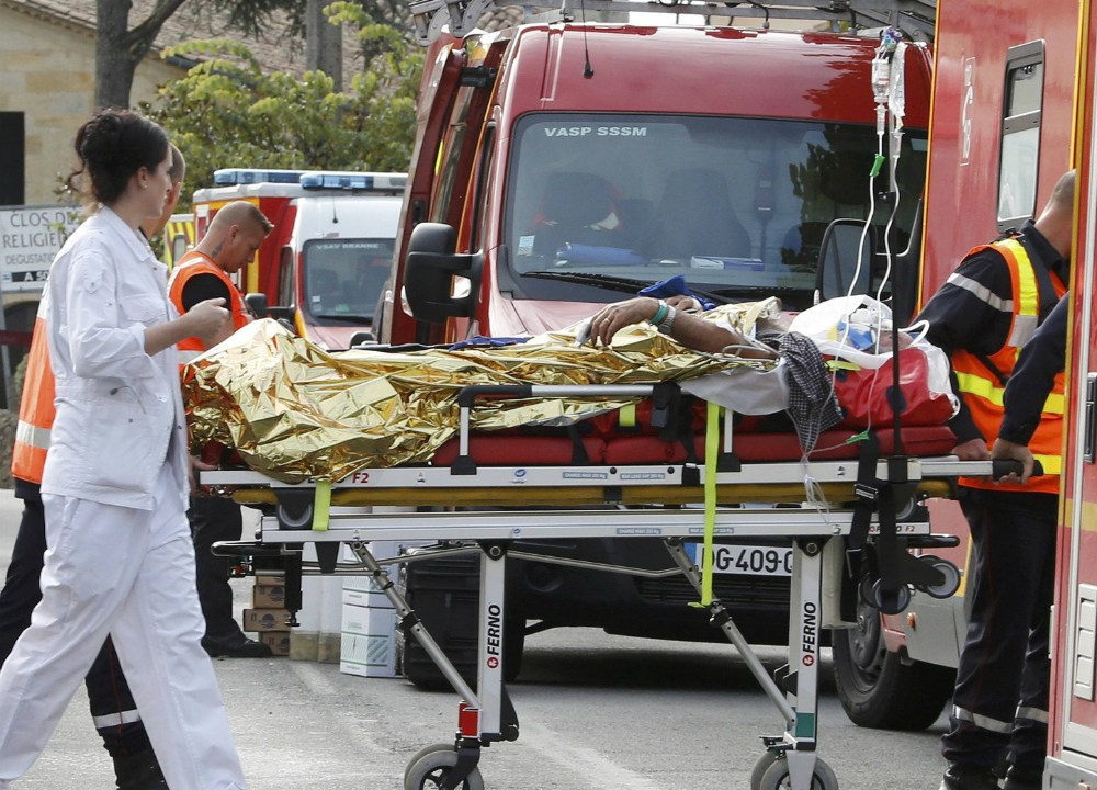 Paramédicos socorrem um sobrevivente do acidente que matou 42 pessoas na França