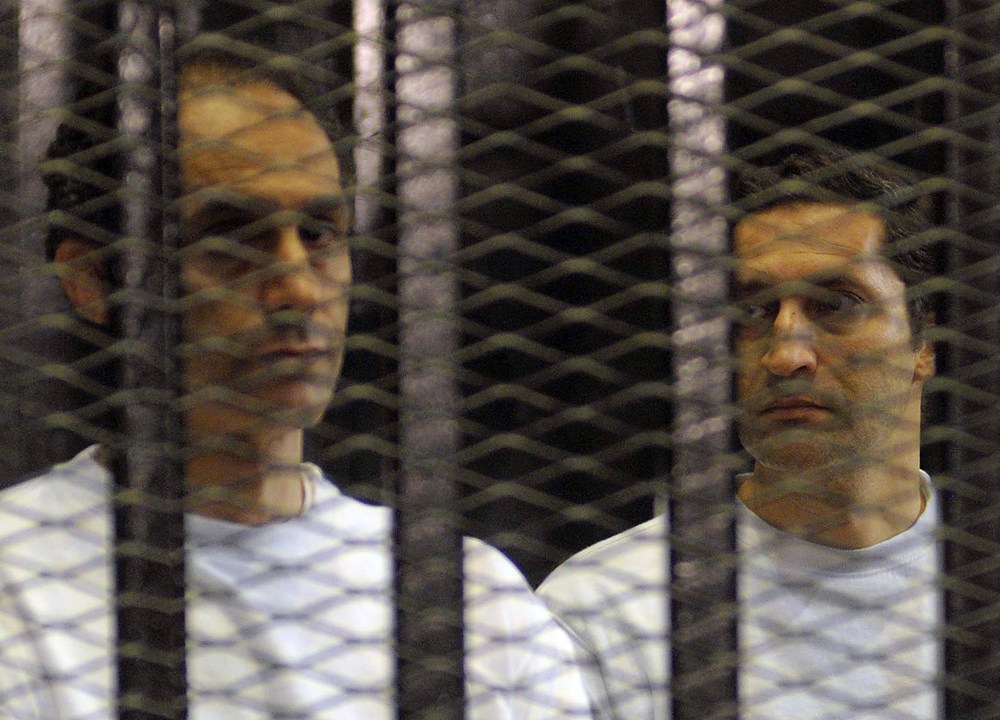Alaa e Gamal Mubarak, filhos de Hosni Mubarak, presos em foto tirada durante o julgamento dos dois, em Cairo