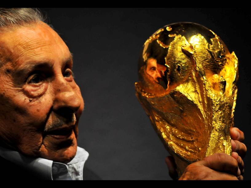 Alcides Ghiggia carrega o troféu da Copa do Mundo durante evento de chegada do troféu ao Uruguai, em janeiro de 2013