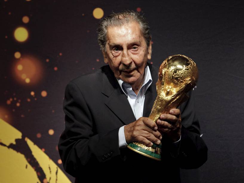 Alcides Ghiggia posa com o troféu da Copa do Mundo durante a turnê do troféu de 2014