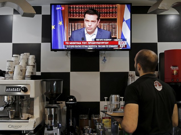 Garçom assiste ao pronunciamento do primeiro-ministro grego Alexis Tsipras, em Atenas, Grécia. Tsipras pediu para que os gregos votem "não" no referendo de domingo