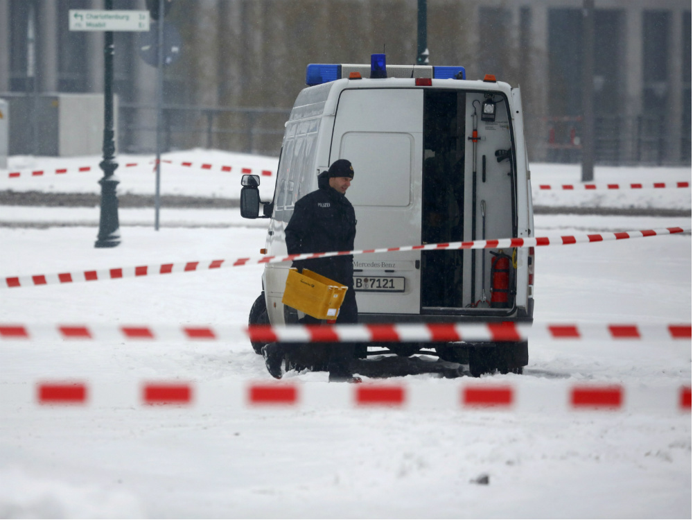 Policial remove o pacote postal suspeito próximo ao gabinete de Angela Merkel