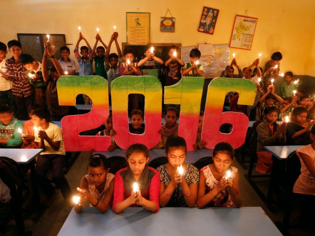 Em Ahmedabad, na Índia, crianças fazem orações pedindo a paz mundial no próximo ano de 2016