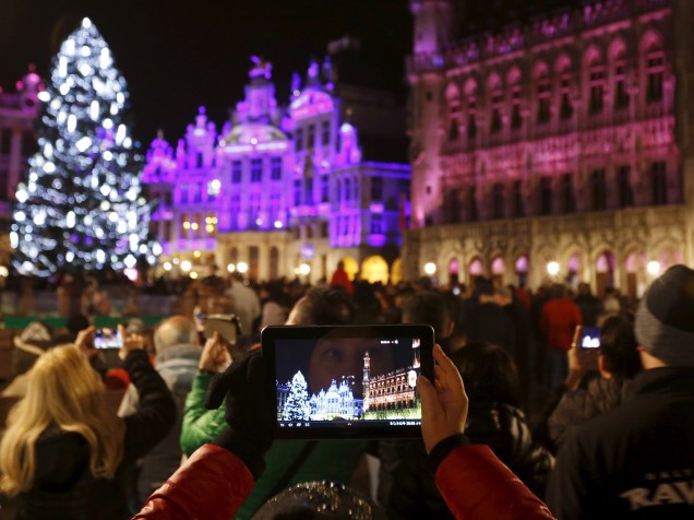 Turista tira fotos do show de luzes na véspera de ano novo em frente ao Palácio Real de Bruxelas