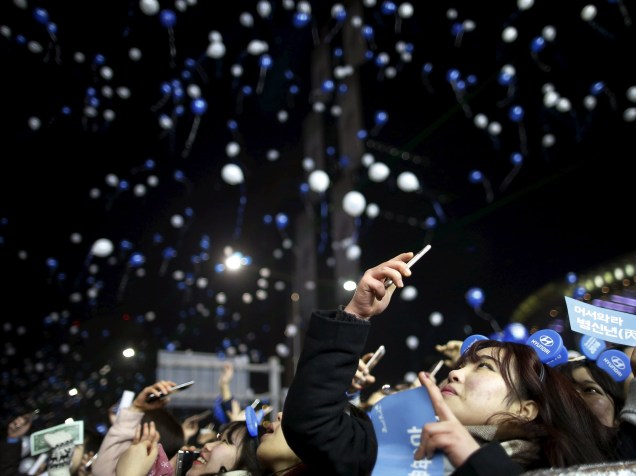Mulher fotografa os balões soltos durante a comemoração do ano novo em Seul, Coréia do Sul