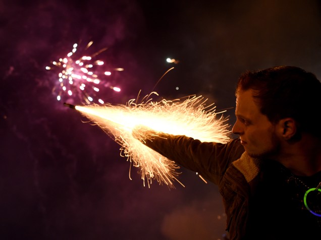 Homem dispara um sinalizador durante celebrações de Ano Novo na cidade alemã de Colônia