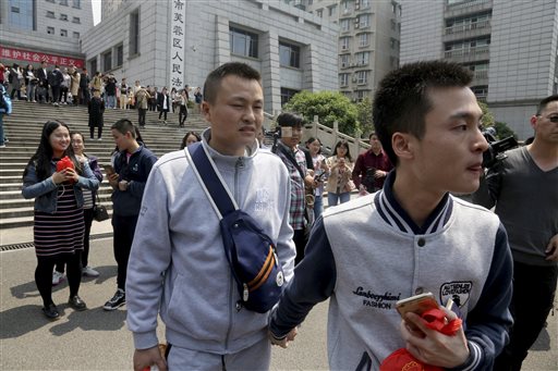 Sun Wenlin e seu parceiro Hu Mingliang deixam a corte da China depois de o juiz rejeitar o pedido de registro de casamento do casal - 13/04/2016