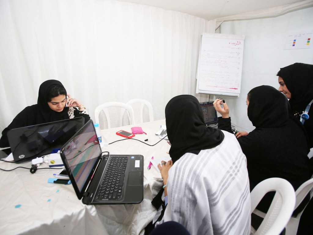 Membros da equipe de comunicação de uma candidata às eleições municipais na Arábia Saudita trabalham em sua campanha