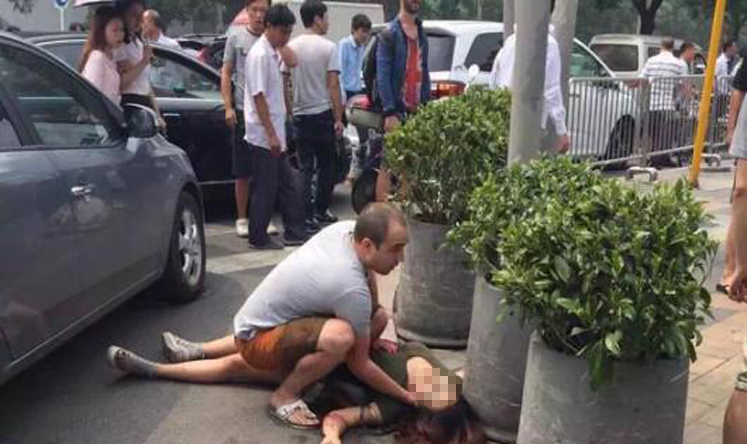 Um turista socorre um mulher atacada com uma espada no centro de Pequim