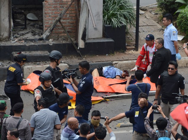 Polícia verifica vítimas de um ataque diante de um posto de polícia, em Jacarta, na capital da Indonésia