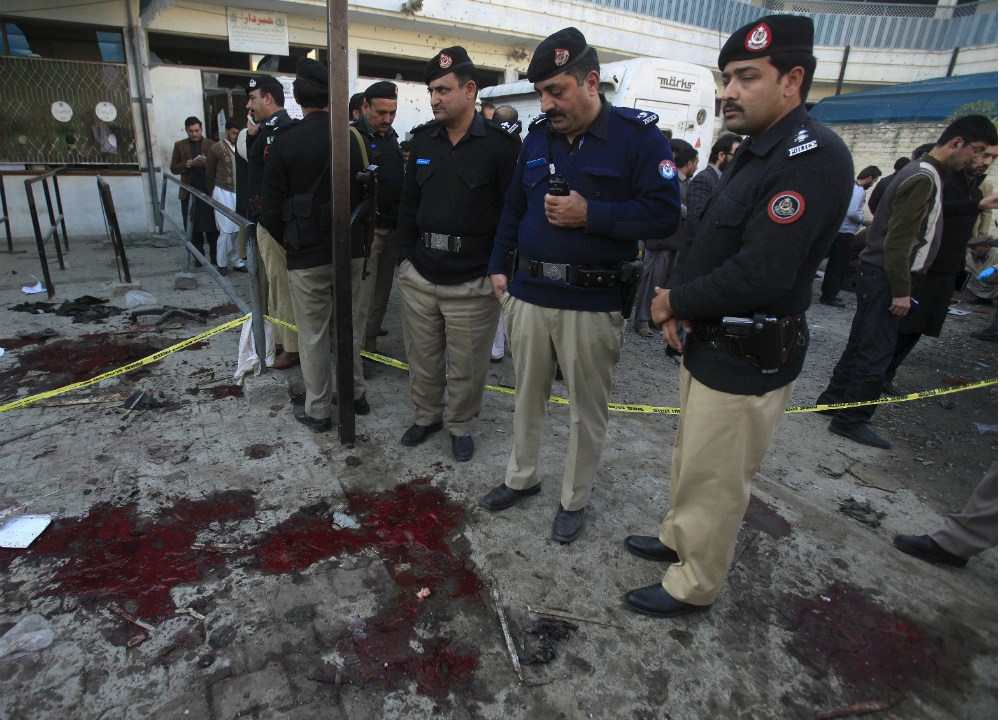 Policiais inspecionam o local do atentado, em Mardan, no Paquistão