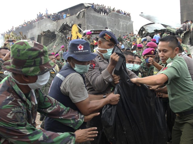 Equipe de resgate carrega o corpo de vítima da queda do avião militar C-130 Hercules, após queda em uma área residencial na cidade de Medan, na Indonésia. O avião de transporte colidiu dois minutos após a decolagem, a cinco quilômetros de distância da base