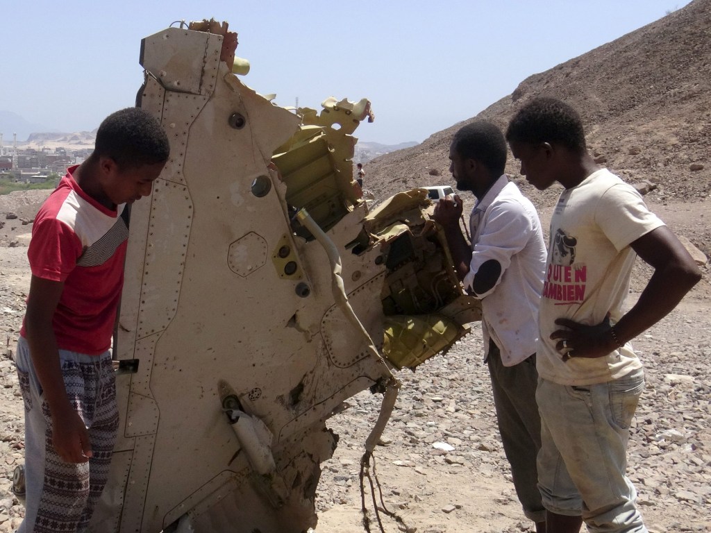 Garotos observam destroços de avião dos Emirados Árabes que caiu no Iêmen, matando os dois pilotos, nesta segunda-feira (14)