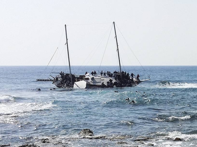 Imigrantes que tentavam chegar a Grécia, são vistos na água tentanto alcançar a costa da ilha de Rodes