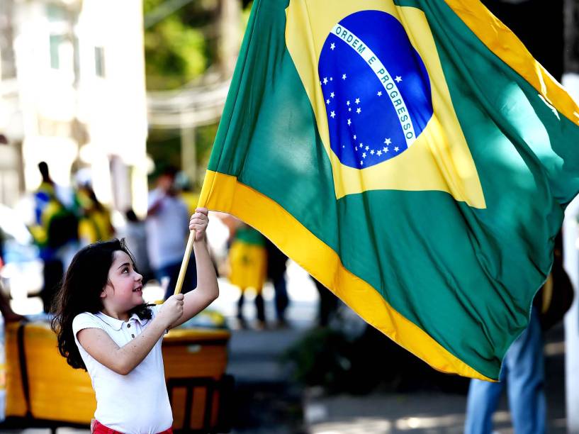 Menina é fotografada segurando a bandeira do Brasil na Arena do Palmeiras, em São Paulo