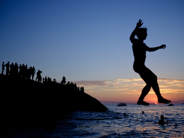 <p>Garoto brinca durante o pôr do sol na praia do Apoador, no Rio de Janeiro - 18/01/2015</p>