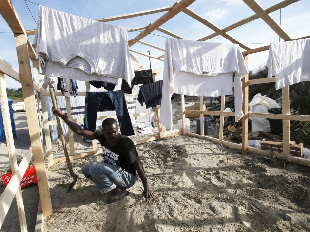 Imigrante trabalha em acampamento improvisado em Calais, norte da França
