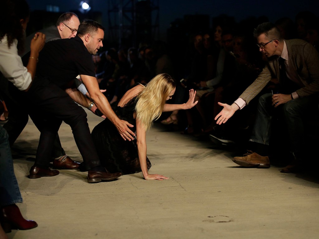 A modelo Candice Swanepoel recebe auxílio após cair durante desfile da Givenchy, em Nova York