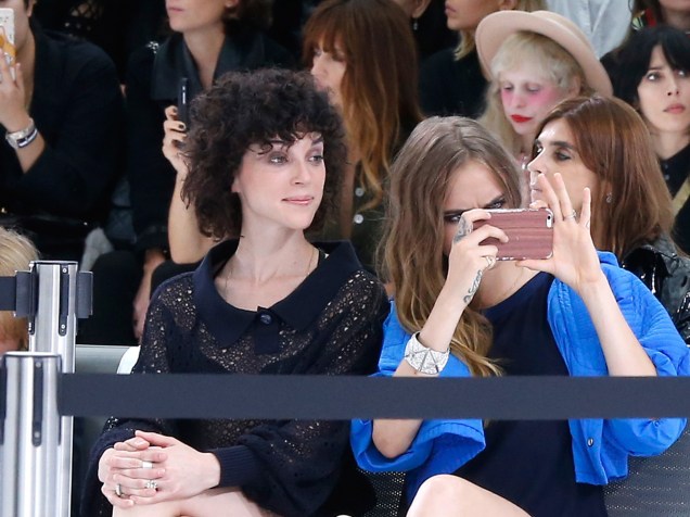 A cantora St. Vincent e a modelo Cara Delevingne são vistas usando o mesmo anel no dedo anelar durante a Paris Fashion Week