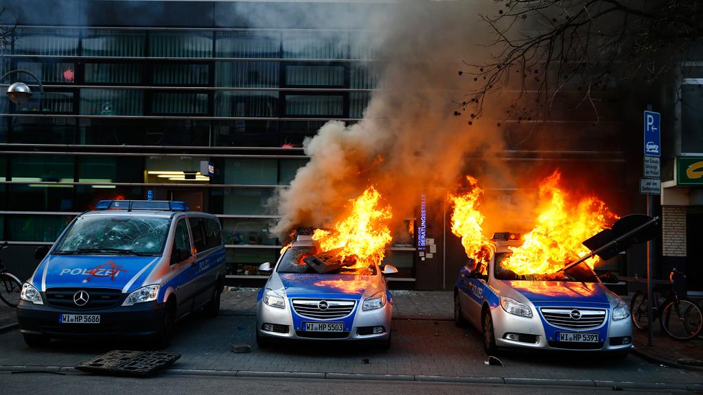 Carros policiais incendiados próximos à nova sede do BCE, em Frankfurt