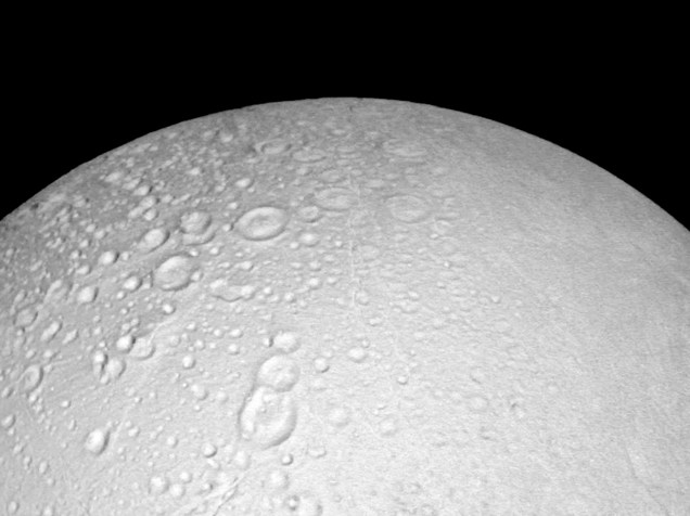 <p>Polo Norte de lua Enceladus de Saturno, em  imagem da sonda Cassini de 14 de outubro de 2015. Na foto é possível observar as crateras da superfície a uma distância de 6.000 quilômetros</p>