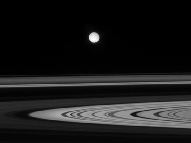 <p>Os anéis de Saturno e sua lua Enceladus em imagem registrada pela sonda Cassini da Nasa</p>