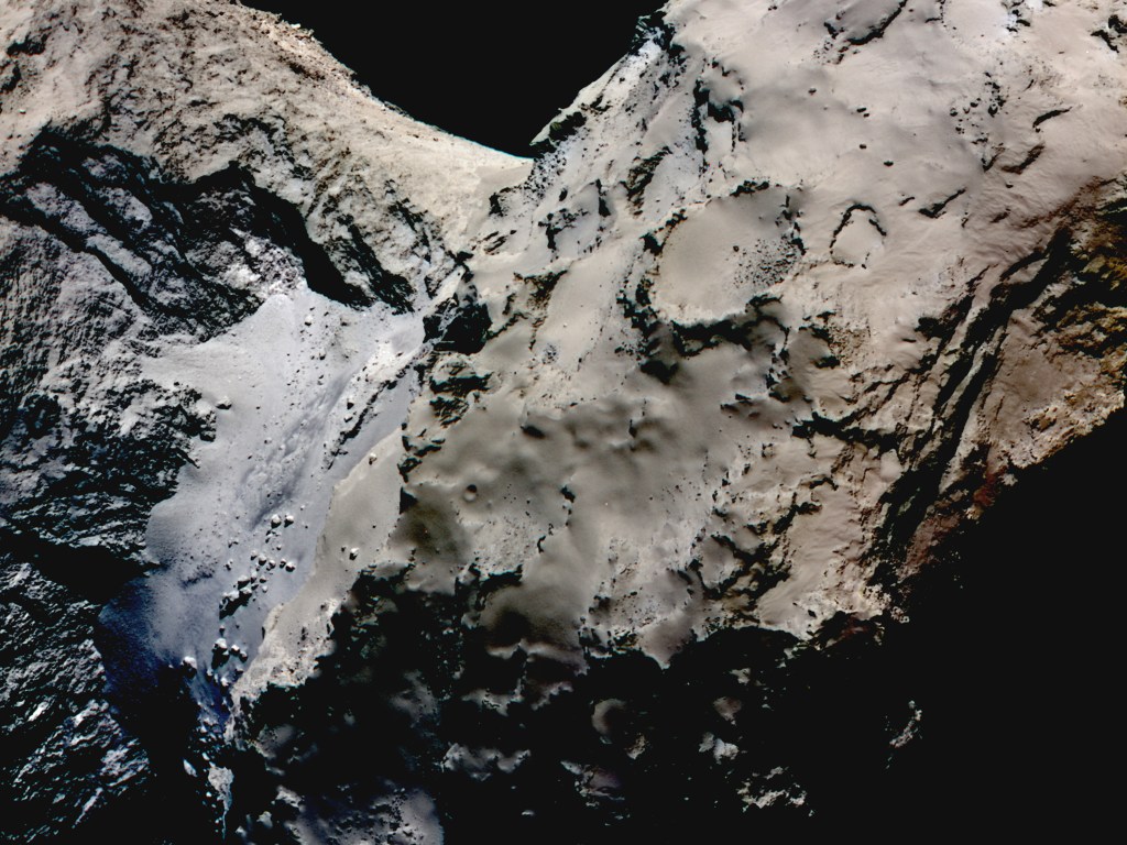 Diferença de coloração entre a região do 'pescoço' (mais azulada) e o resto do cometa. Nesta imagem, as cores foram reforçadas para ressaltar a diferença