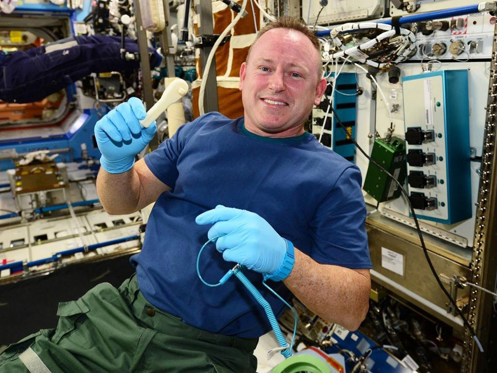 O astronauta Barry Wilmore segura a ferramenta impressa no espaço