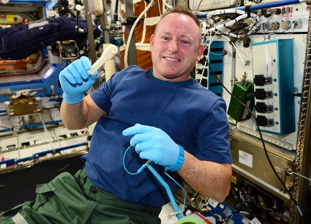 O astronauta Barry Wilmore segura a ferramenta impressa no espaço